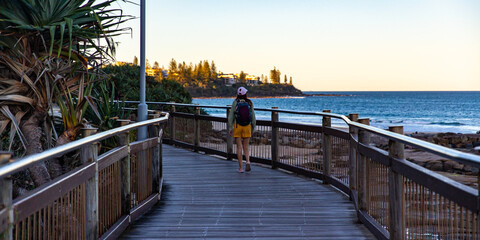 beautiful girl enjoys a sunset at kings beach, caloundra in sunshine coast, queensland, australia;...