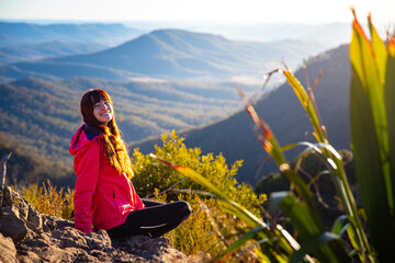 beautiful hiker girl enjoying sunset over unique, folded mountains in south east queensland,...