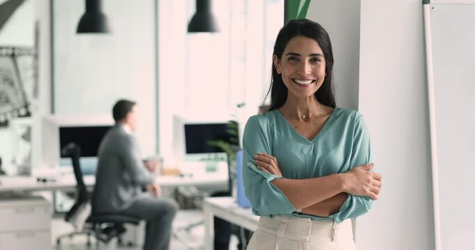 Department executive manager, professional worker portrait. Successful promoted female employee smiling, looking at camera posing in modern co-working office, take break, photoshooting at workplace
