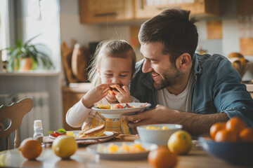 father feeds his daughter during breakfast at dining table