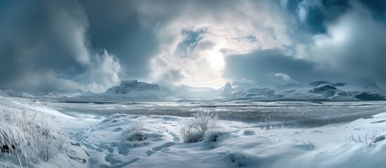 Obraz premium A snowy landscape stretches out before us, with towering mountains in the background under a cloudy winter sky. The snow creates a serene and stunning view.