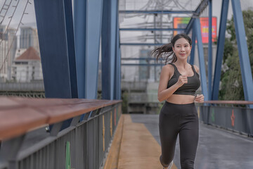 Fit muscular young woman runner sprinting at great speed outdoors on the river bridge. beautiful fitness girl on the street. beautiful fitness girl on the street.