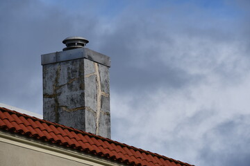 Chimney against dark stormy sky.