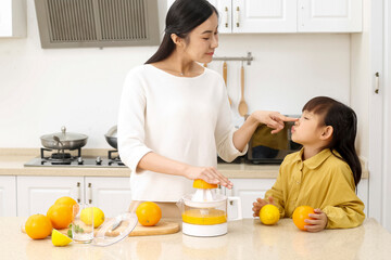 Making juice in the kitchen. Asia. Mother and daughter making juice together.