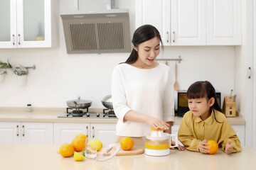 Making juice in the kitchen. Asia. Mother and daughter making juice together.