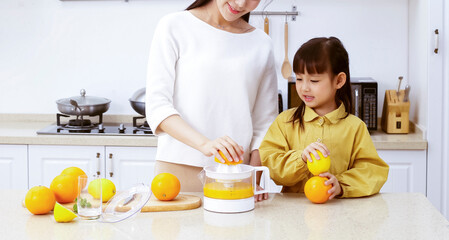 Asian mother making fresh juice with her daughter