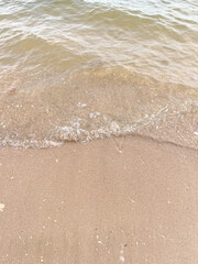 Soft wave of blue ocean on sandy beach. Background.