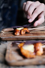 Chicken skewers with sauce on a plate over a light grey slate, stone or concrete background. in Hong Kong fine diningrestaurant	
