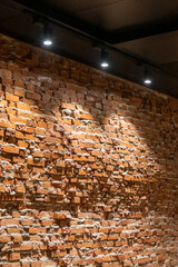 Brick wall with spotlight from the ceiling, highlight its texture