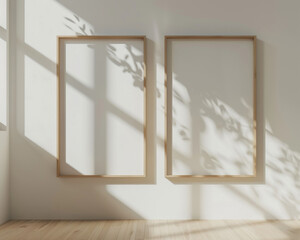 Two clean and streamlined wooden frame blank mockups mounted on a white wall, illuminated by natural sunlight from the side, featuring an organic texture and bright photography setting.