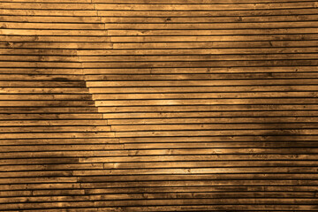 brown Wall fence old weathered wood battens which are located in two overlapping layers. yellow stacked wooden backgrounds form overlapping lines.