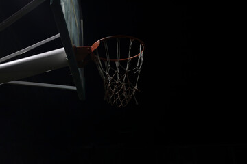 view of the basketball hoop at an empty playground outdoor court at night. Side view of basketball...