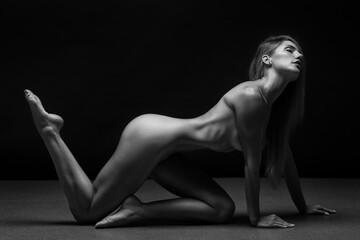 Abstract fine-art portrait. Black and white photo of nude beautiful woman. Female body on black...