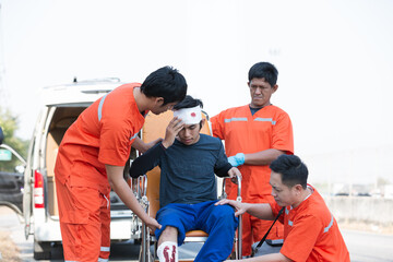 Injured man broken head and bandage on patient transport stretcher. Ambulance staff member...