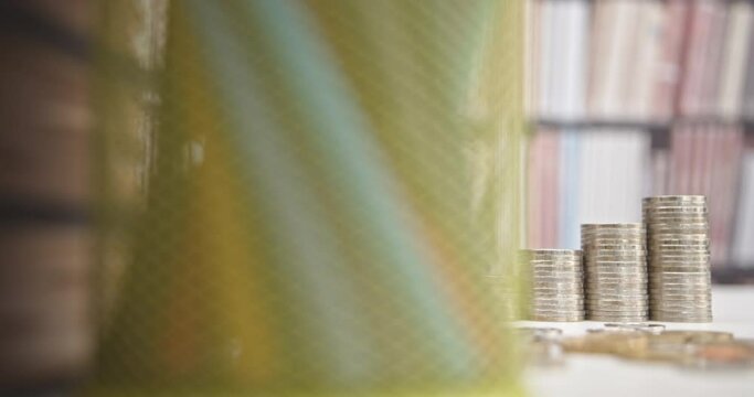 Student loans : Financial aid helping students afford higher education. Borrowed funds for college or university expenses. Black graduation cap, books and increasing height coin stacks on a table. 