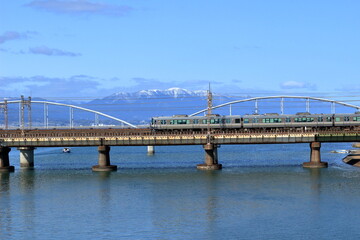 雪の積もった蓬莱山と瀬田川を渡る橋