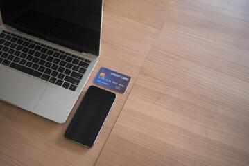 Credit card, laptop and smartphone on table, online shopping