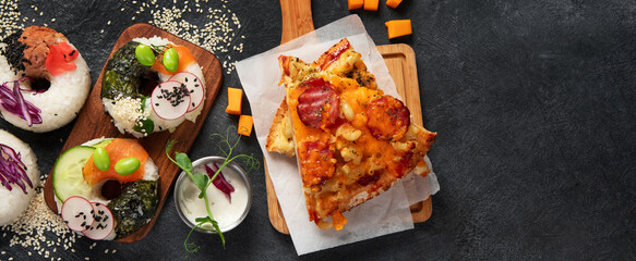 Hybrid trendy food on dark background. Sushi roll pancake, donut sushi, pizza with pasta