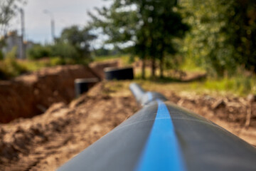 Close-up of a large industrial plastic polypropylene water pipe at a construction site for laying...