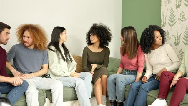 Multi-ethnic group of people talking sitting in apartment