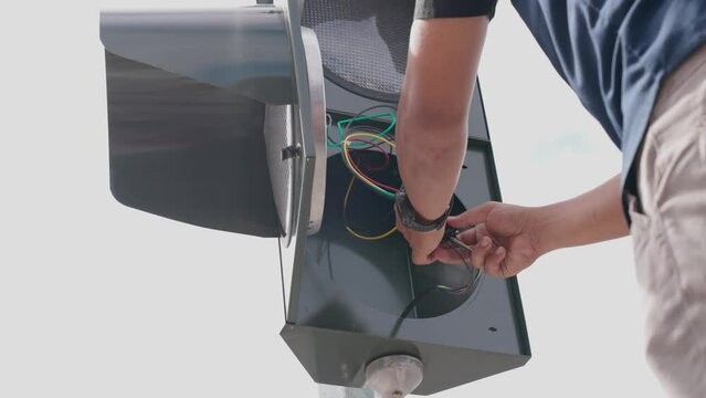 A technician repairs a traffic light