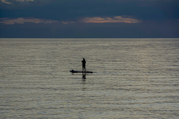 Girl woman practices paddle standing on the beaches of Glenelg, Australia.