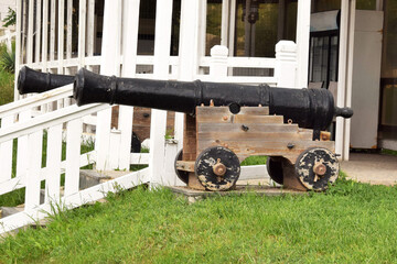 antique cannon on a carriage with cast iron cannonballs