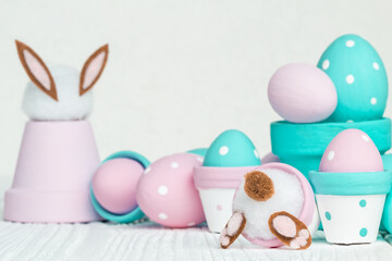 Fototapeta na wymiar Cute Easter decorations, flowerpots and handmade Easter eggs in pastel colors