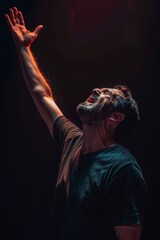 A Christian man praying to God crying and emotional with his arms raised