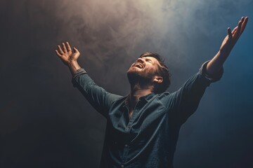 A Christian man praying to God crying and emotional with his arms raised