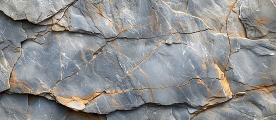 This close-up view showcases the intricate details of a rock wall featuring prominent cracks and scattered patterns. The weathered surface of the stone reveals years of natural wear and tear.
