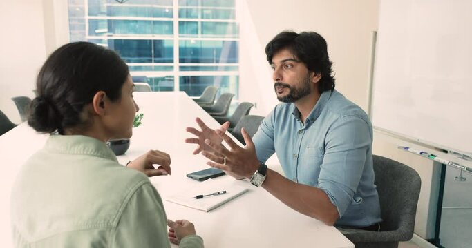 Indian boss, male executive manager provide information to client, tell about agreement term, deal details, conduct briefing, teach young female employee, speaking, share solution and ideas at meeting