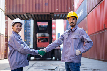 Engineers shaking hands congratulating themselves on success with shipping containers in the...