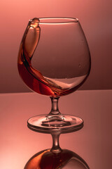 splash in a glass goblet with liquid on a colored background