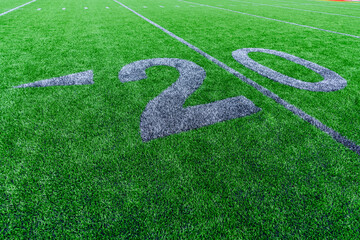 Synthetic turf football 20 yard line and block style numbers in gray.  Practice football turf...