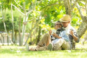 Asian senior elderly retire couple drinking coffee in the nature park happy and relax time.  People...