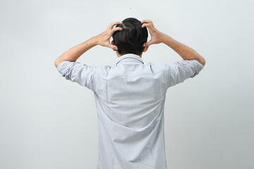 back view of asian indonesian man with hand grab his head showing stressful confused gesture....