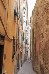 Fototapeta na wymiar Genoa, Italy - July 11, 2019: Labyrinths of narrow streets and alleys of the old city - Caruggi di Genova
