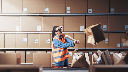 Aggressive rebellious worker smashing boxes at work