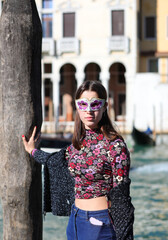 young girl with mask posing in Venice on the bank of the Grand Canal in Venice in Italy