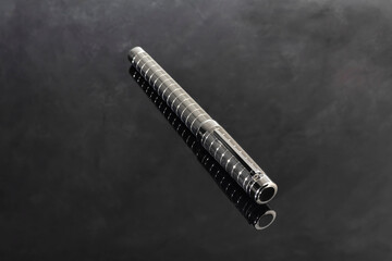 Fountain pen on marble and gray background with reflection. Vibration focus.