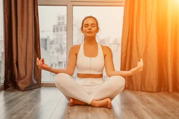 Foto op Plexiglas Young woman meditating at home. Girl practicing yoga in class. Relaxation at home, body care, balance, healthy lifestyle, meditation, mindfulness, recreation, workout, fitness, training concept © svetograph