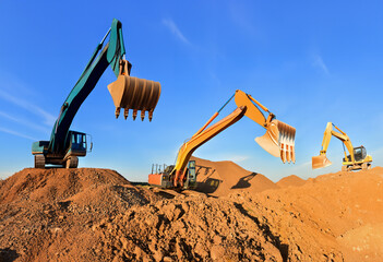 Excavator works on a construction site during excavation work against a blue sky background. Open pit development for sand extraction