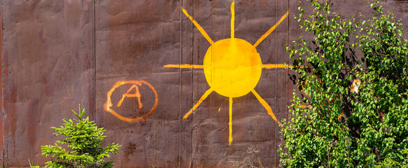 A drawing of the sun on rusty iron.