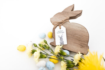 Yellow and blue pastel colored eggs and yellow flowers and Easter bunny on a white background. Food...