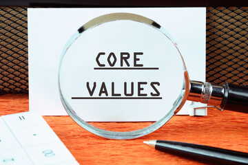 CORE VALUES word written on a white card through a magnifying glass