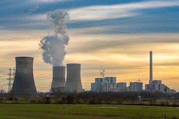 Nuclear power Energy concept - Nuclear power plant with yellow field and big blue clouds. Nuclear...