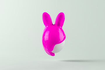 Easter egg with bunny ears painted in pink paint on blue pastel background. Creative Easter concept.