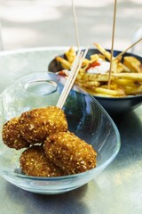 Spanish tapas. Delicious croquettes in the foreground accompanied by french fries with mayonnaise and ketchup.
