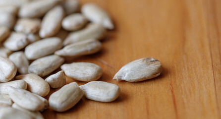 Sunflower seeds scattered on wooden surface, close-up, macro